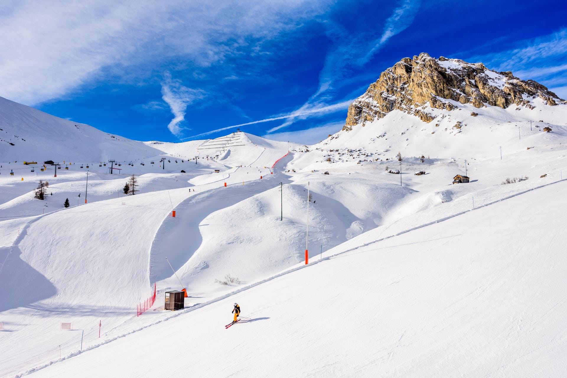 A skier traversing the Sellaronda circuit, the legendary interconnected ski route around the Sella massif in Northern Italy.