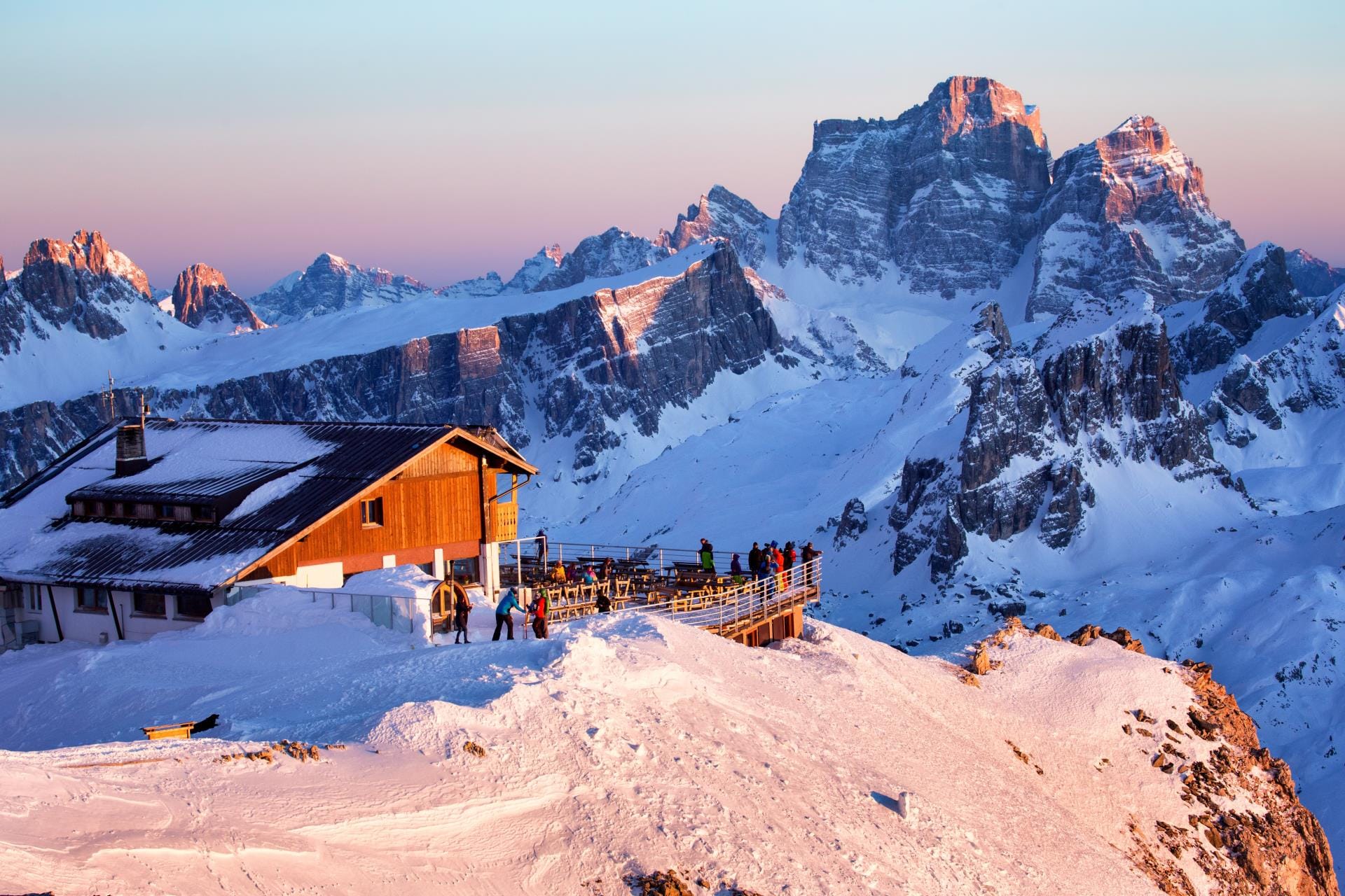 Sunset at Rifugio Lagazuoi with the cable car station overlooking the pink-hued peaks of the Dolomites near Cortina d’Ampezzo.