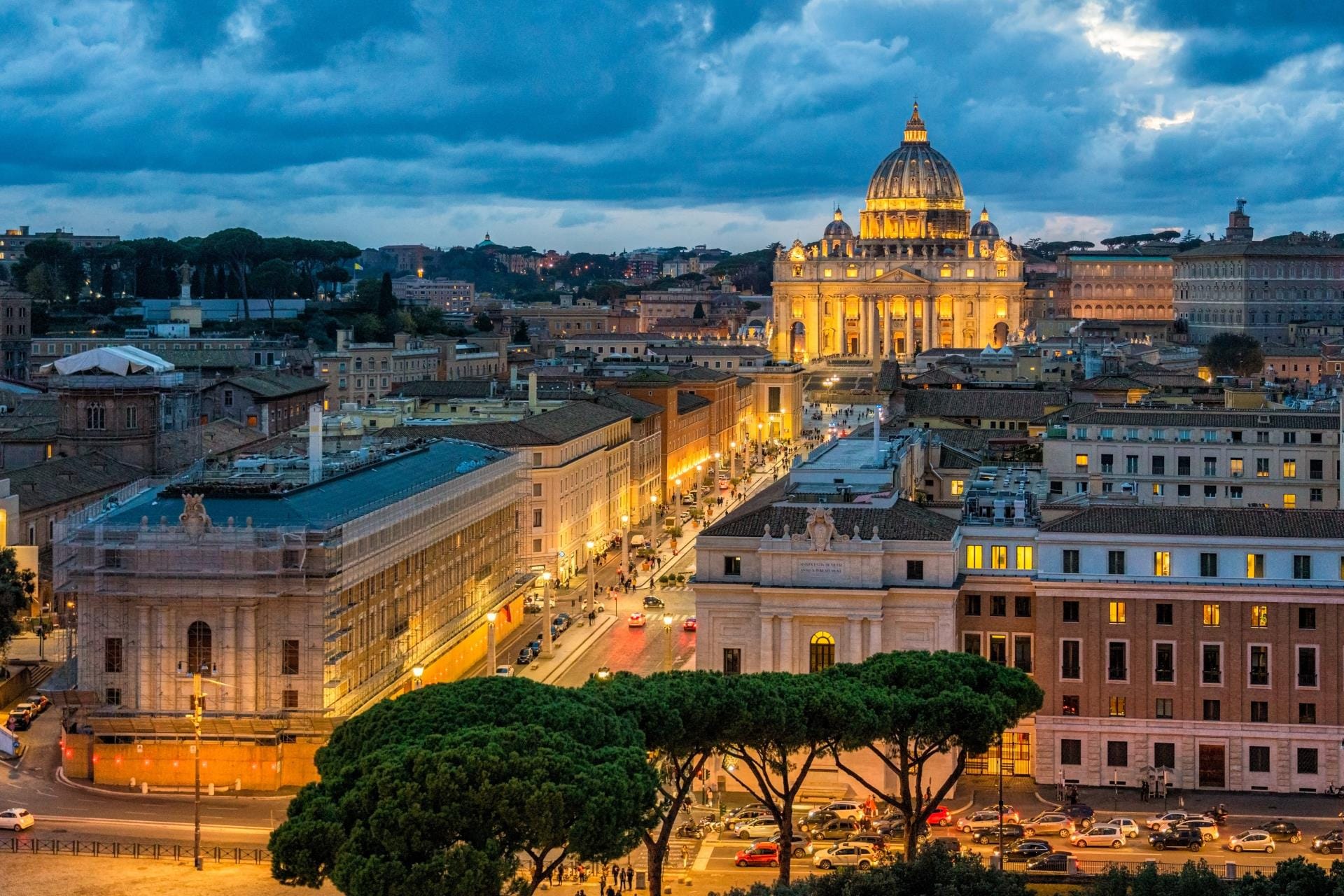 Panoramic night view of the illuminated St. Peter's Basilica seen from the rooftop terrace of Castel Sant'Angelo.
