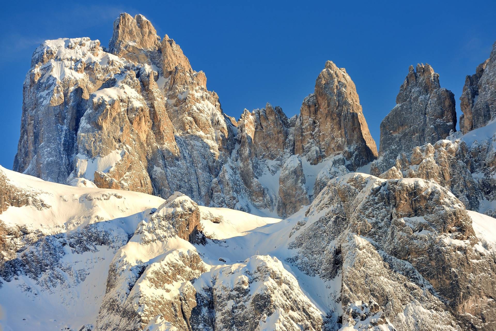 The snow-capped peaks of the Pale di San Martino Dolomites viewed from Val Venegia on a bright, sunny winter day.