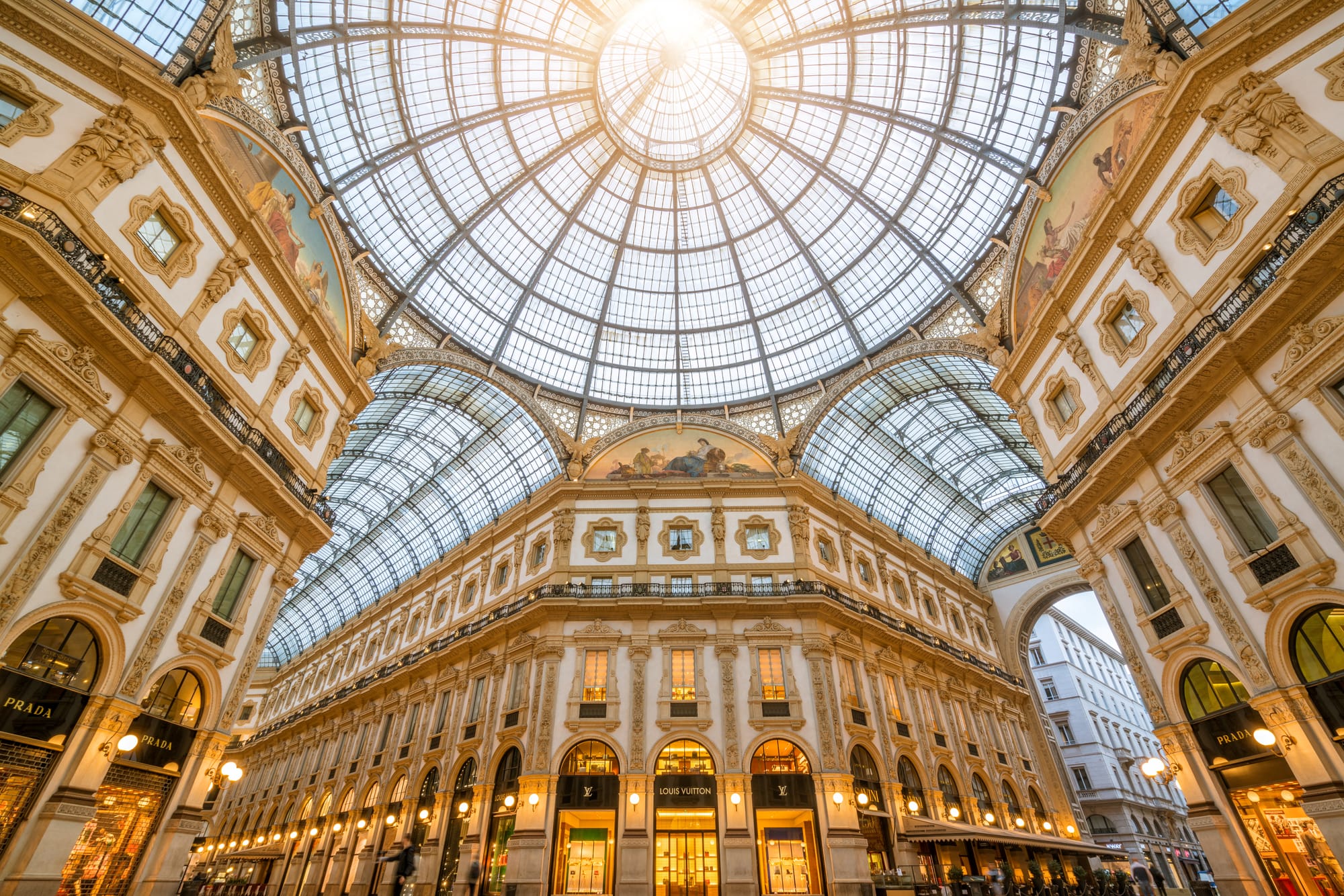 The grand, triumphal arch entrance of Galleria Vittorio Emanuele II in Milan, a 19th-century architectural masterpiece and luxury shopping arcade next to the Duomo.